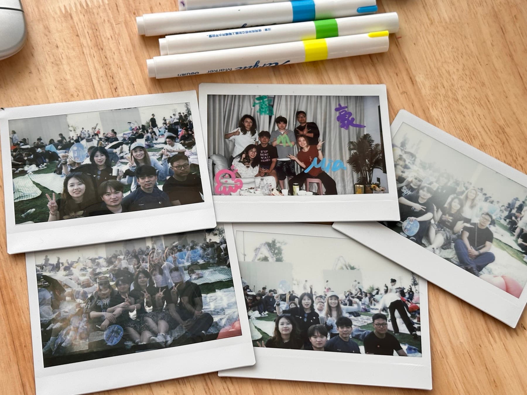 Several polaroid photos spread on a wooden table