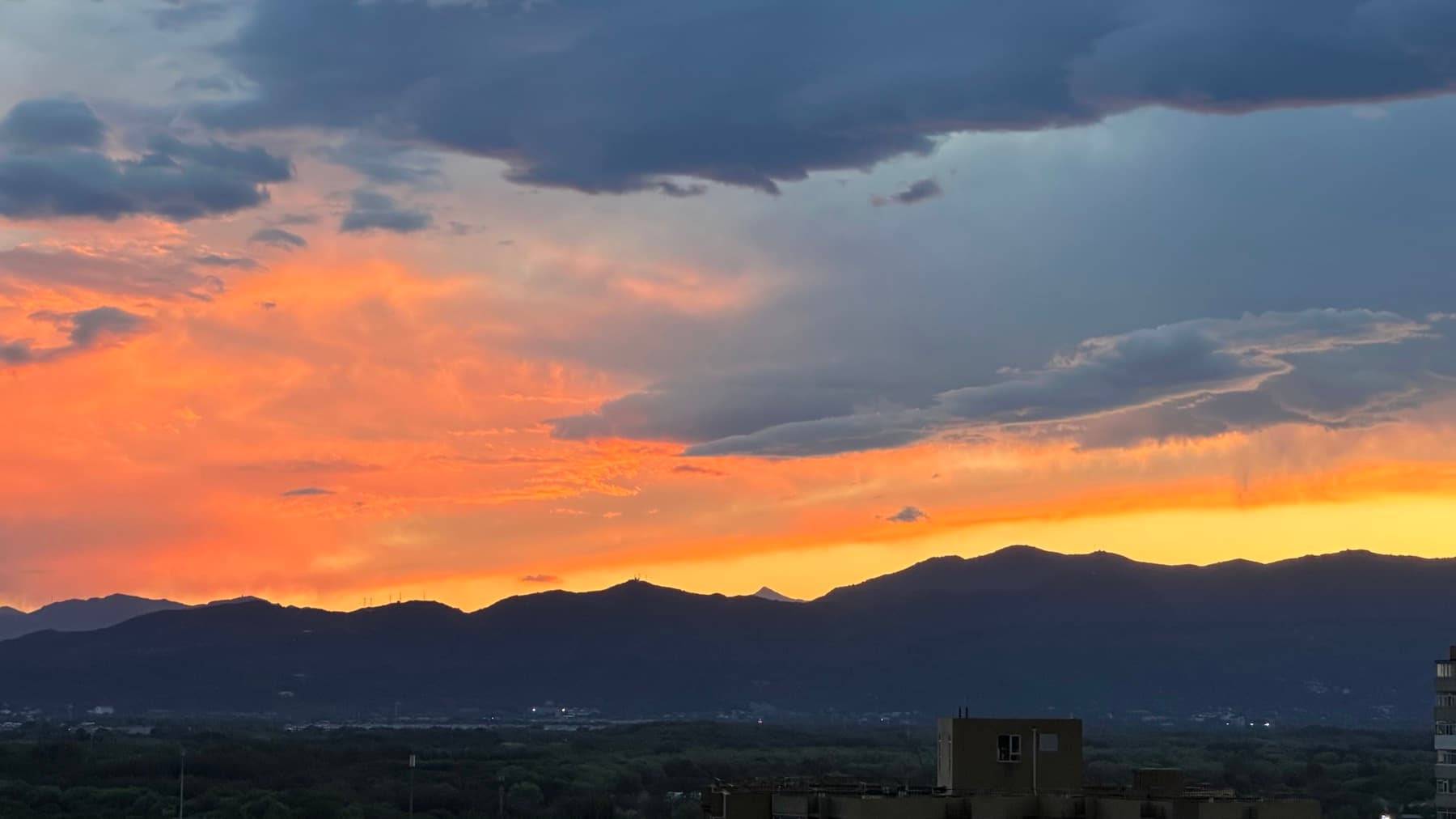 Orange sunset over mountains and clouds